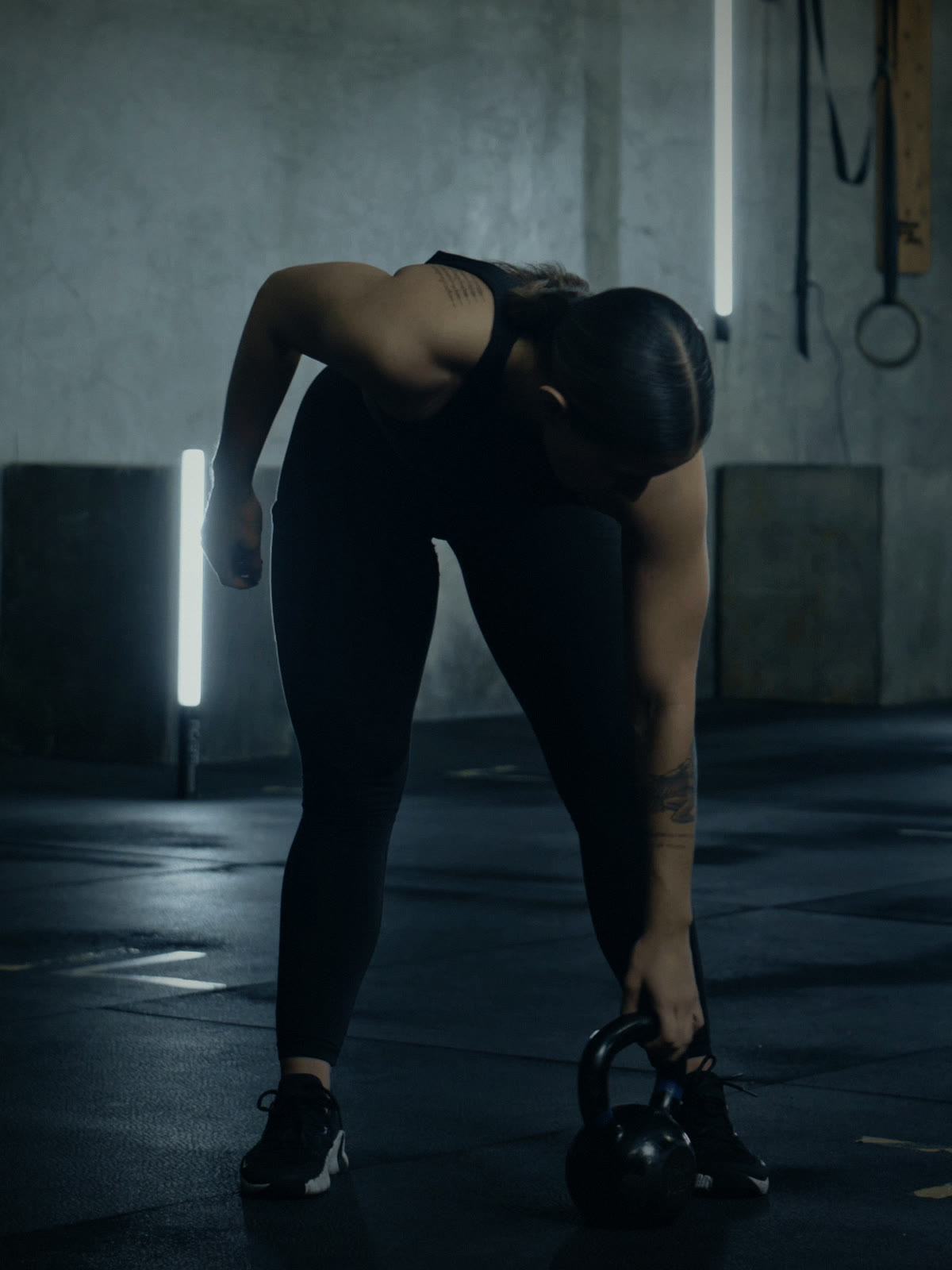 The conditioning coach lifting a kettlebell off the gym floor
