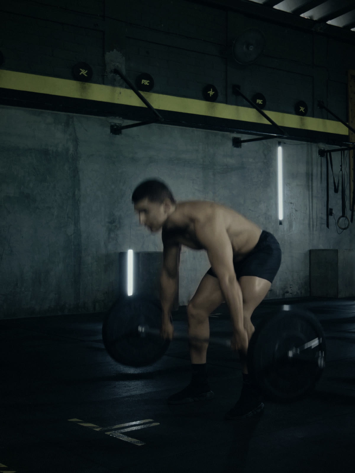 The lifting coach setting up over a barbell on the floor
